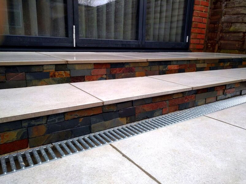 Porcelain patio with steps and drainage grate