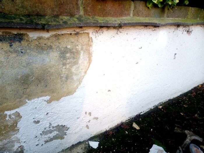 Garden wall with flaking render