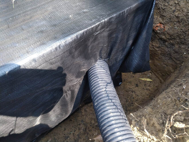 Perforated pipe into drainage crate