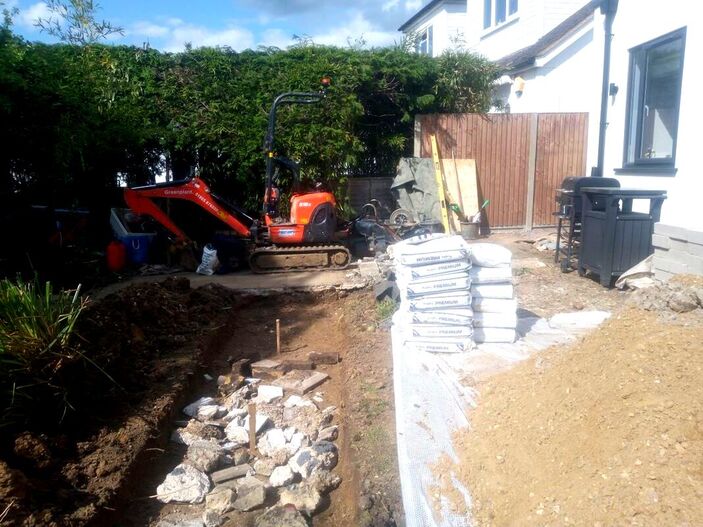 Excavating concrete garden wall foundation