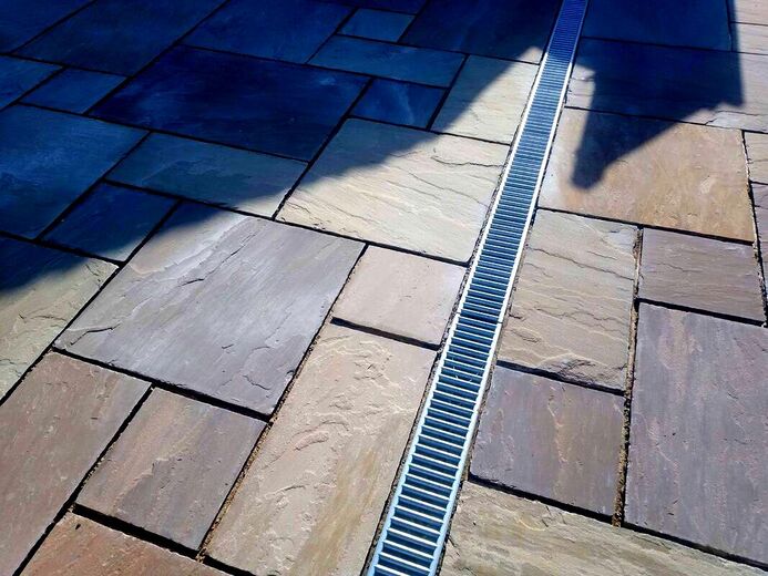 An Indian sandstone patio with acco drainage chamber