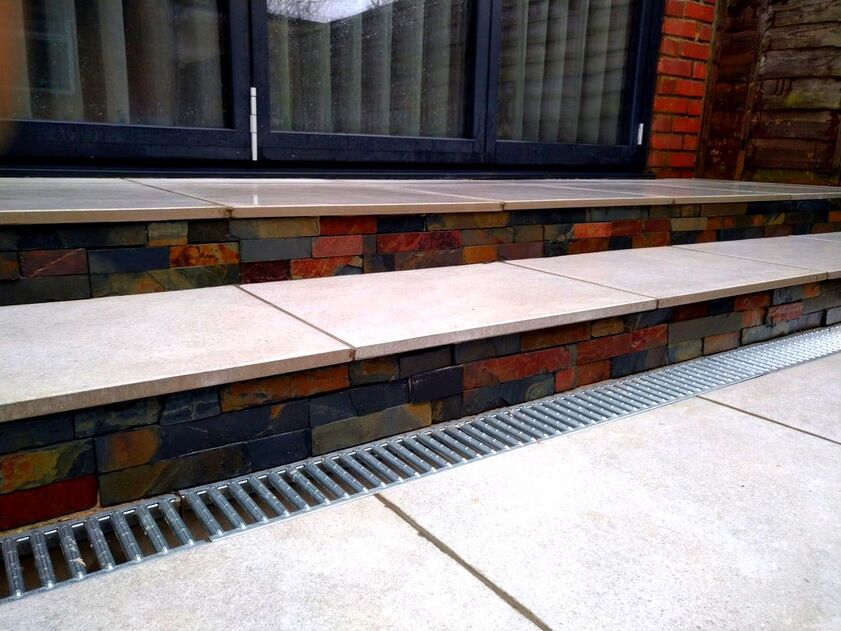 Porcelain patio with steps and drainage grate