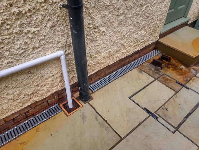 Grated channel drain by home