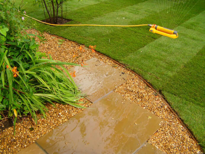 Watering new lawn with sprinkler